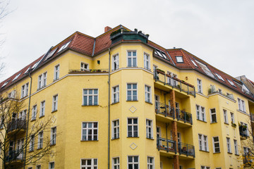 Fototapeta na wymiar yellow big apartment building in berlin on a cloudy background