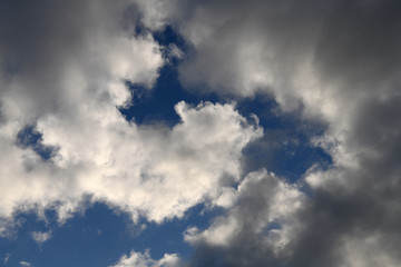 青空と雲「空想・雲のモンスターたち（画面中央付近と上の部分に左向きの顔イメージなど）」（何かを見つけて叫ぶ、誰かを見つけて呼びかける、親子で、仲間となどのイメージ）