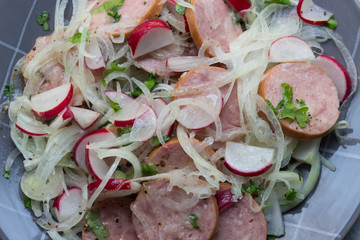 Wurstsalat mit Essig, Öl und Zwiebeln sauer angemachter Salat aus Wurst auf einem Teller