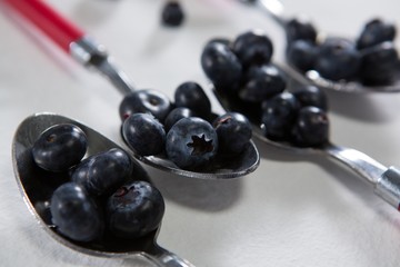 Blueberries arranged in a spoon on white background