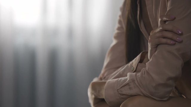Sad woman sitting on couch and thinking about husband, loneliness and melancholy