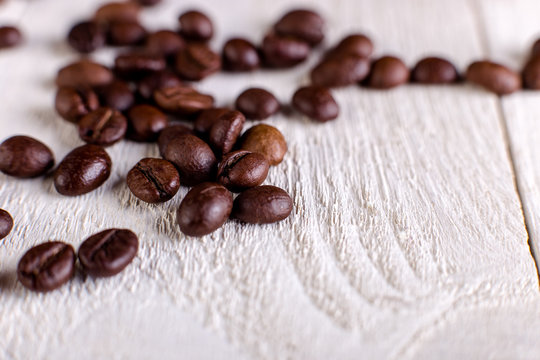 Coffee beans or grain on white wooden background. Flat lay.