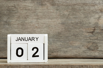 White block calendar present date 2 and month January on wood background