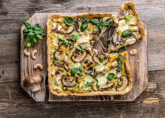 Homemade mushrooms pie on a wooden background.