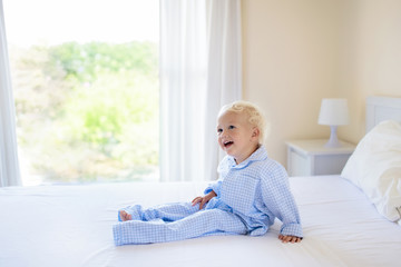 Kids in bed. Children in pajamas. Family bedroom.