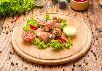 Stuffed chicken breast wrapped in bacon on a plate close-up. horizontal
