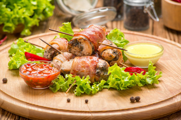 Stuffed chicken breast wrapped in bacon on a plate close-up. horizontal