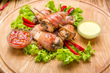 Stuffed chicken breast wrapped in bacon on a plate close-up. horizontal