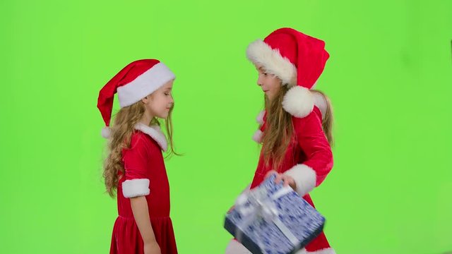 Child gives a New Year gift to her friend. Green screen. Slow motion
