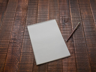 Notepad with a pen on a wooden table.