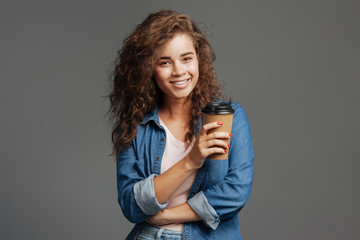 Cheerful curly woman drinking coffee
