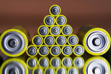 Stack of yellow AA batteries close up abstract color background