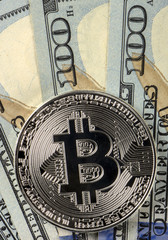 Coins bitcoin on a background of 100 American dollars close-ups