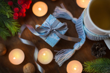 Christmas gift box decorations on wooden background with scafr and cup of tea