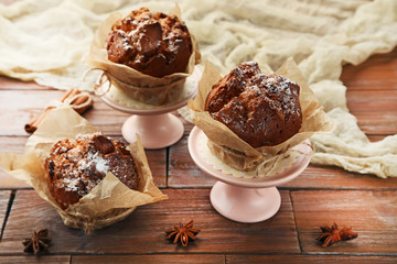 Tasty muffins with cinnamon and star anise on brown wooden table