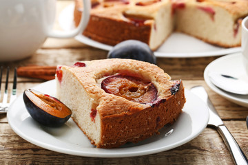 Sweet plum cake on brown wooden table