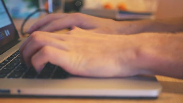 man typing on the laptop keyboard close up
