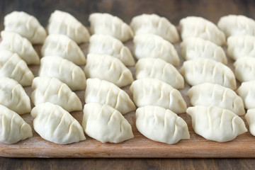 Fototapeta na wymiar Many raw Jiaozi or Gedza Chinese dumplings, common in East Asia.
