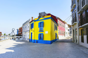 Typical house painted in the typical colors of the town, yellow and blue, on the street called "Cais dos Botiroes" with cobblestone floor, in the village of Aveiro (Portugal)