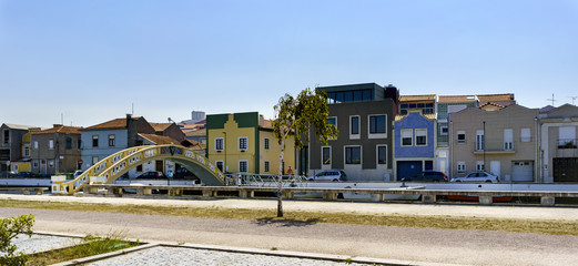 View of the bridge called of lovers on the main canal and typical village houses facades. With a blue sky without clouds