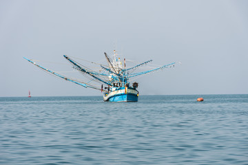Fishing or squid hunter boat in blue sea on solf sky .