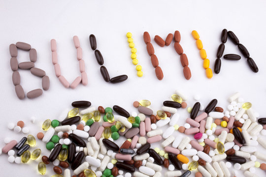 Conceptual Hand writing text caption inspiration Medical care Health concept written with pills drugs capsule word bulimia On white isolated background with copy space