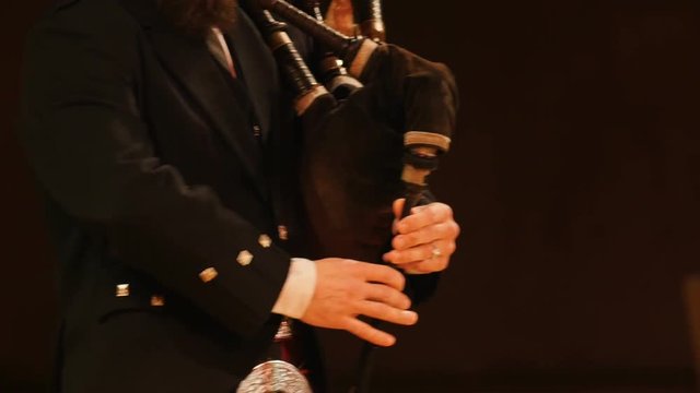 Bagpipe player plays musical instrument at the stage