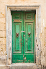 Old green door with lion's head knockers