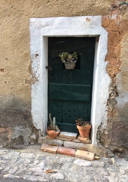 Porte d'une ancienne maison avec des pots de fleurs