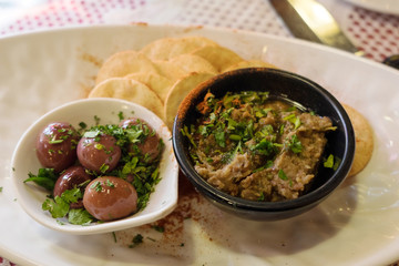 Maltese appetizer - beer snack with soft eggplant pate, pickled olives and salty crackers