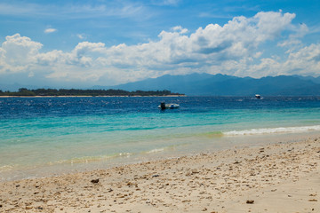 Morning tropical sandy beach with boats in a sea. Gili Trawangan, Indonesia