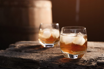 Glass of whiskey on wooden background close up