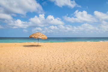 Beach Umbrella and Tropical Turquoise Sea at Cacimba do Padre Beach - Fernando de Noronha, Pernambuco, Brazil.