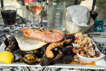 The plate of maltese seafood - freshly caught and grilled octopus tentacles, calamari rings in tempura, giant shrimps, clams, fish fillets and mussels 