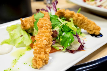Tempura shrimps with lettuce and arugula salad served with herbs, olive oil and mayonnaise sauce
