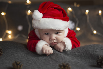 Cute newborn baby wearing Santa hat and clothes. New Year concept