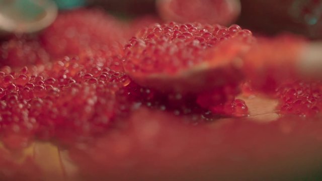 Red caviar dripping from a traditional wooden spoon. Macro food in slow motion,