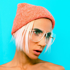Cute Blonde Model in stylish accessories. Beanie and glasses. Casual fashion look