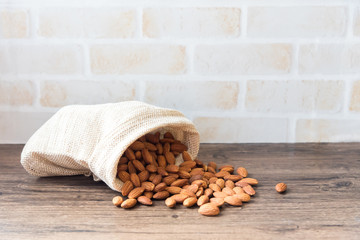 Almond baked in sack bags placed on old wooden floor.
