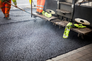 a roadworks on the street new asphalt with worker