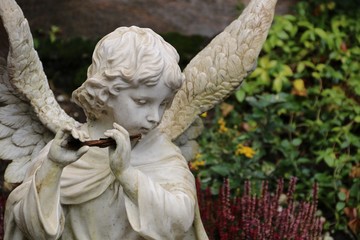 Engel auf dem Friedhof spielt Flöte