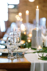 table setting, interior design, entertainment concept. on the blured background of fire lights there is transparen glasses of different shapes ans sizes designed for various drinks