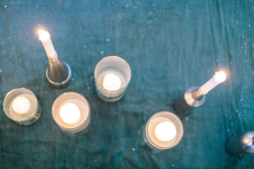 illumination, amusement, home atmosphere concept. blured photo of candles, that are burning placed on the various holders that standing on the floor