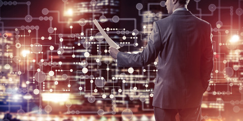 Rear view of businessman against night cityscape background and 