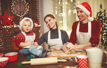 family mother father and baby bake christmas cookies.