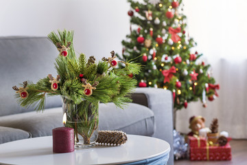 Beautiful Living Room with Christmas Tree ,Presents under it and Pine Branches Bouquet on the Table