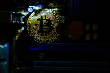 Gold coin of crypto currency bitcoin on computer network chip toned