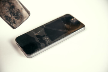 Big hammer breaks the screen of a modern smartphone. Broken glass screen of mobile phone. Crash of...