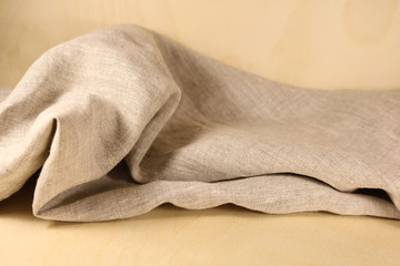 Linen unpainted fabric with folds on the background of wood