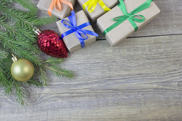 Christmas fir-tree branch, decoration and gift on wooden table